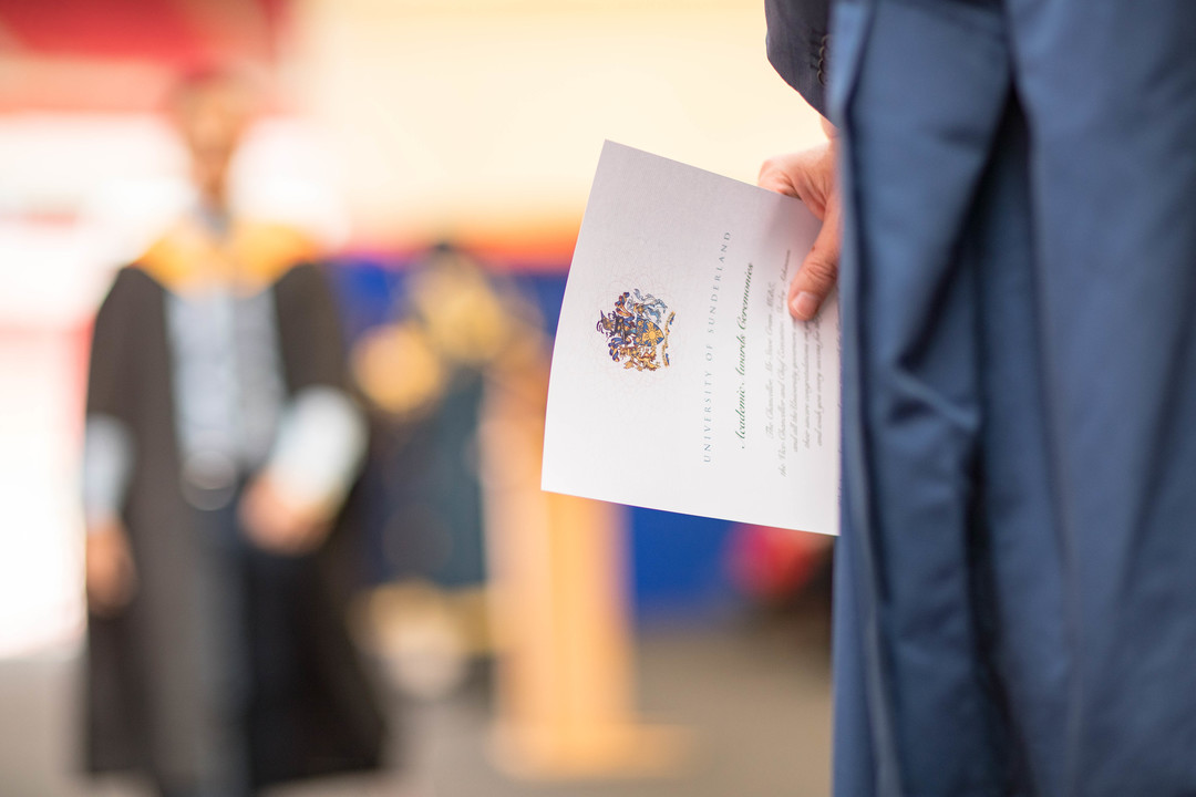 an image of a certificate being handed out at a graduation ceremony